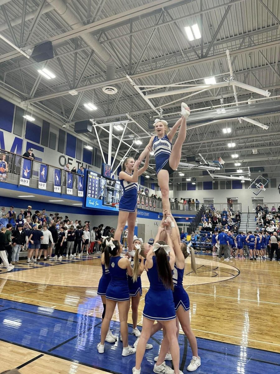 The boys basketball cheerleaders perform a stunt during a timeout.
