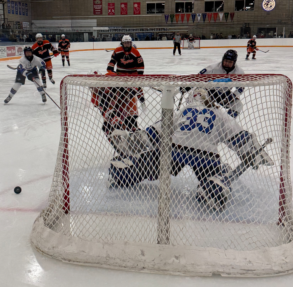 Junior goalie Alexie Olson deflects puck after making a good save against Farmington. 