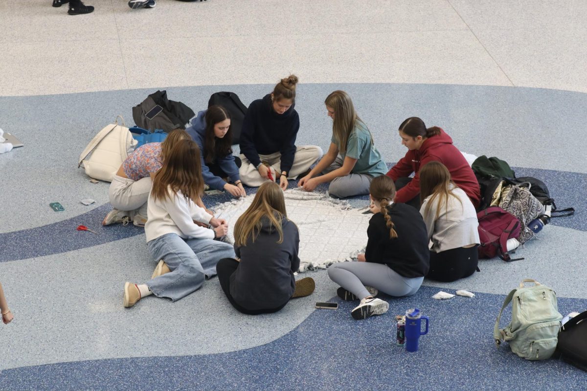 OHS students come together during afternoon Compass time to tie blankets for those in need. 