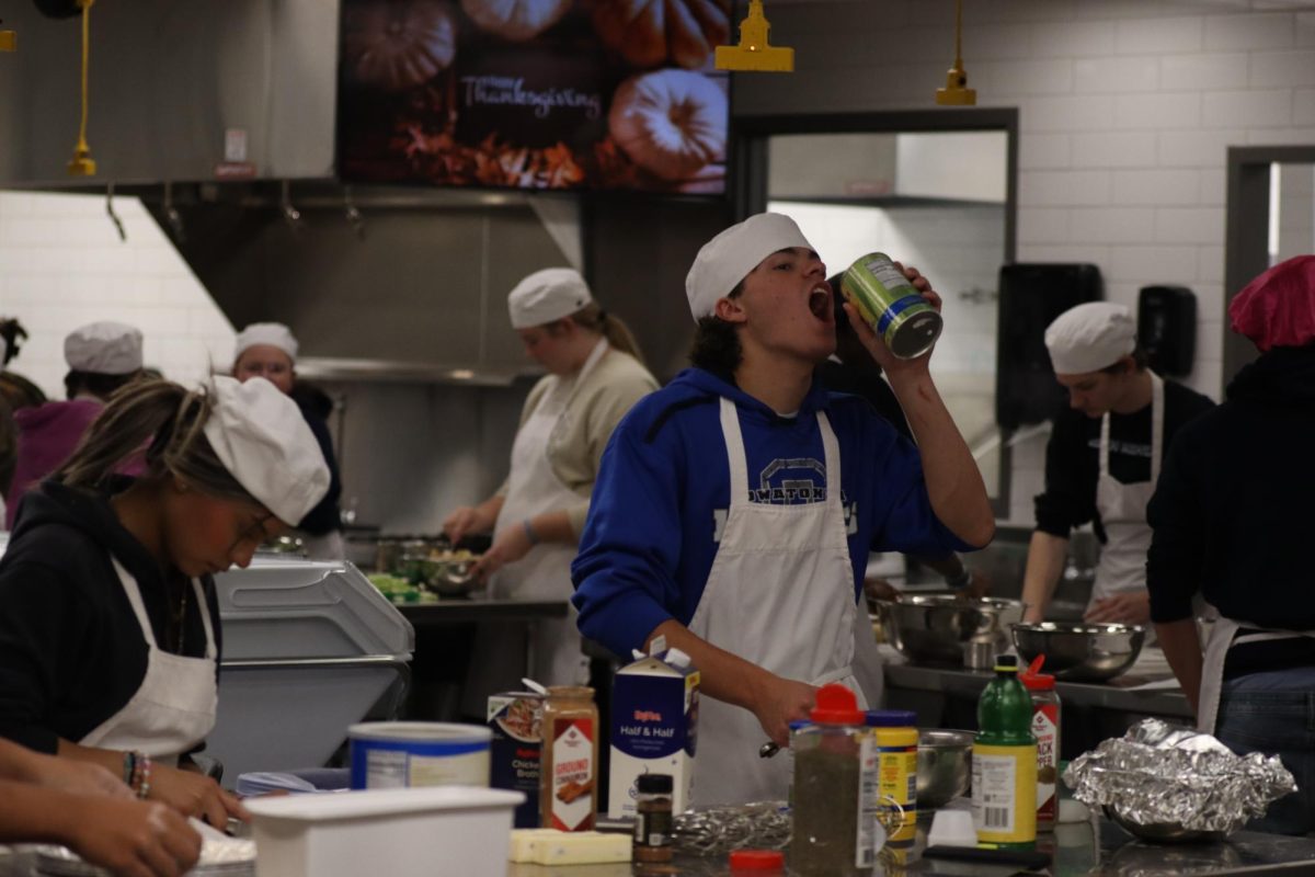 Junior Easton Borwege in foods class attempting to drink pineapple juice. 