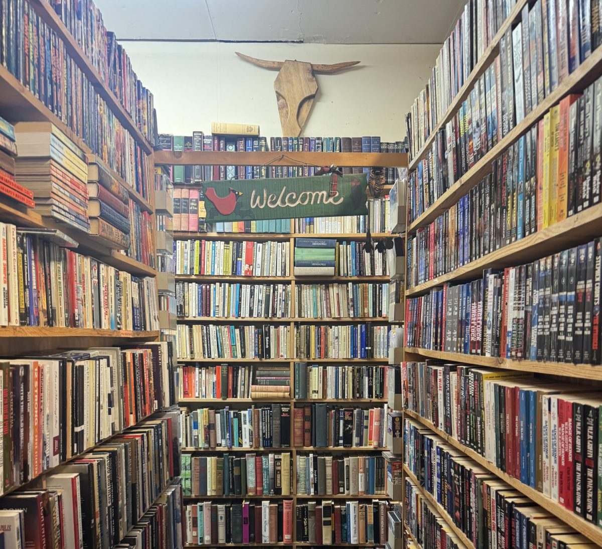 A welcome sign hangs above one of the many shelves inside of Eatons Books. 