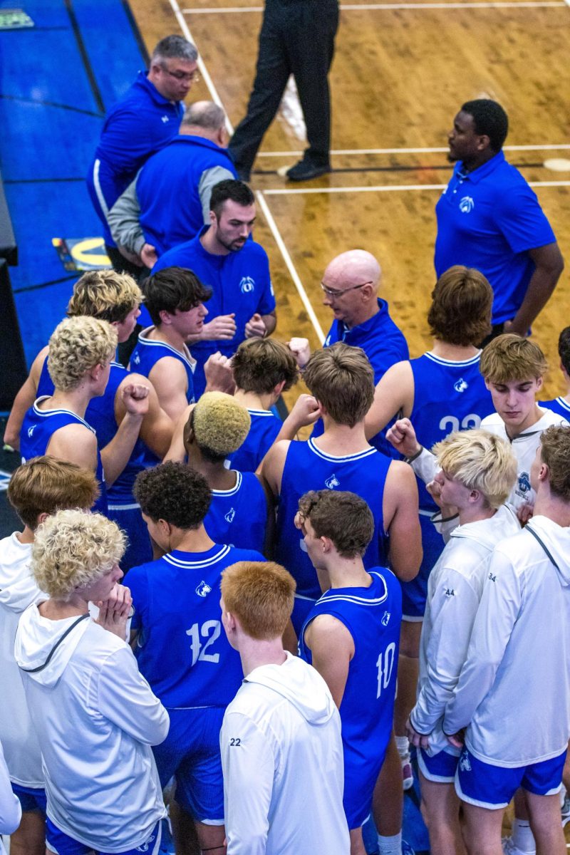 Owatonna Varsity basketball team huddles up prior to the 2nd half with determination.