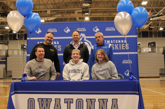 Senior Nolan Ginskey poses with his family after signing. 