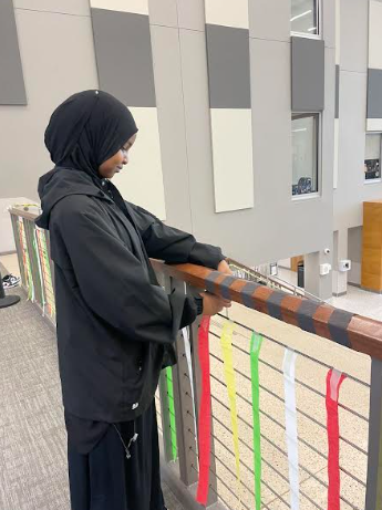 Ramala Dahir (10) decorating the stairway as a part of the RAD Club for black history month. 