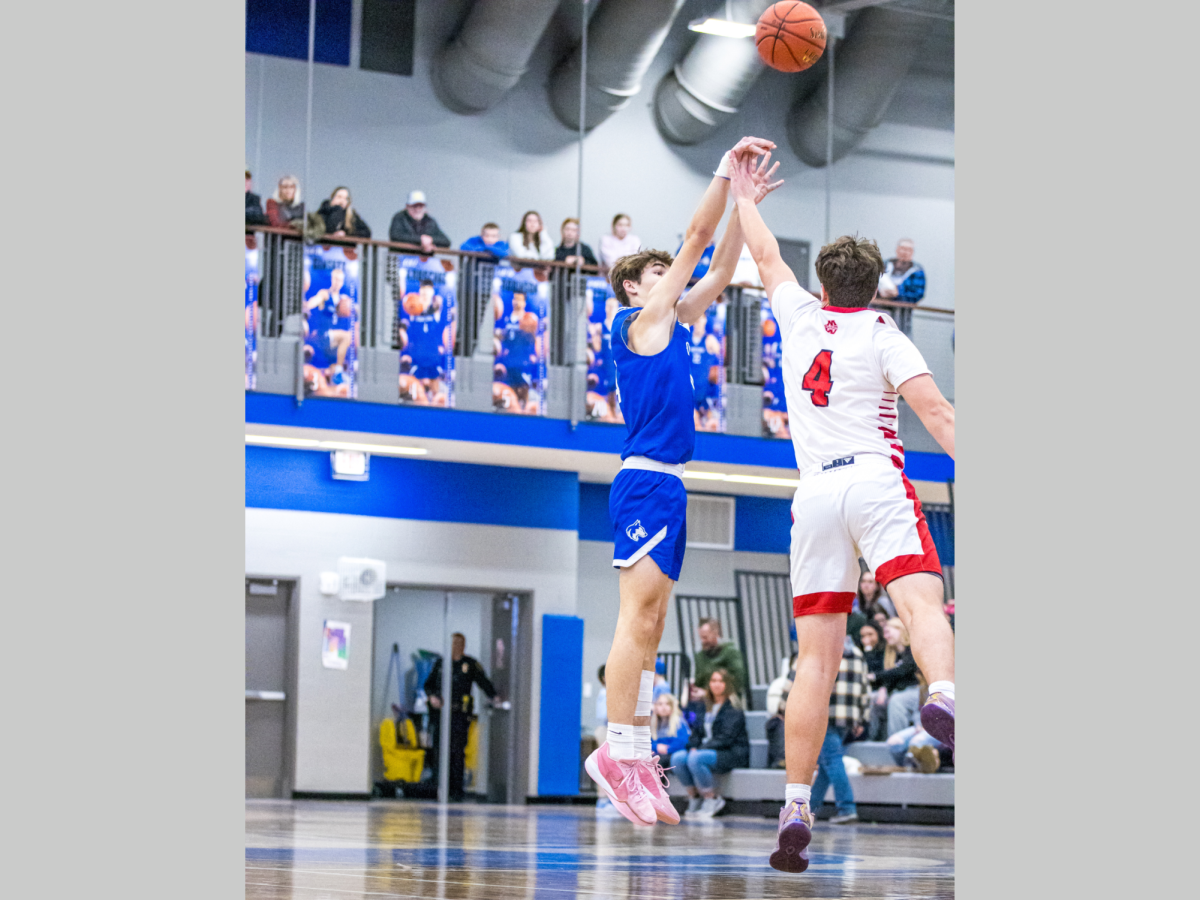 Senior Cole Kruschke attempts a three-point shot in the Huskies face-off against Mankato West.