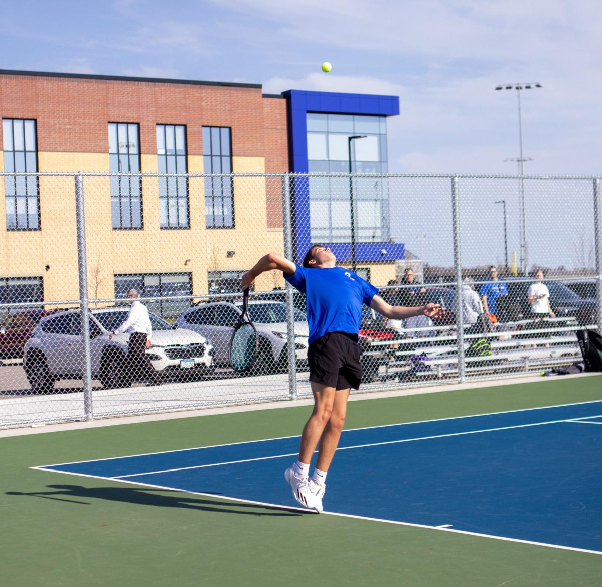 Senior captain Thomas Oien serves the tennis ball.