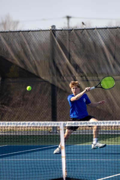 Freshman Tristan Gibart hits the tennis ball.