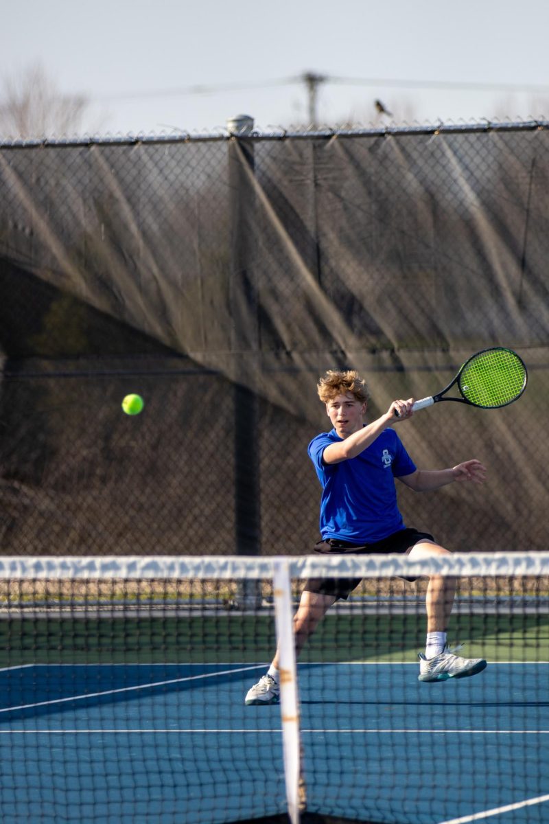 Freshman Tristan Gibart hits the tennis ball.