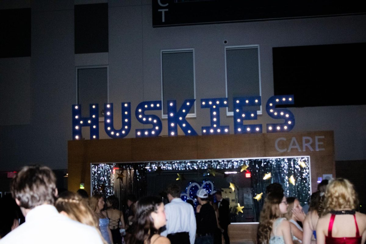 Huskies letters shine bright above the students.