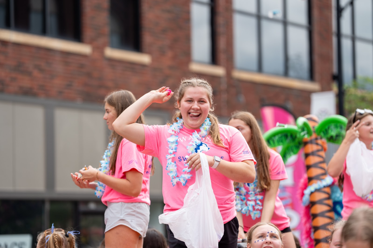 Senior caption Christina Bell throws candy to Owatonna community during the 2025 homecoming parade. 