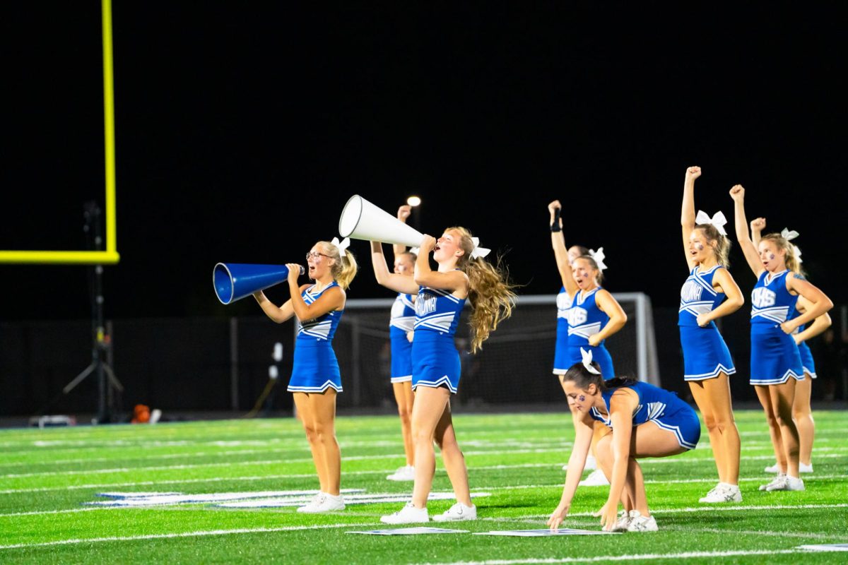Senior Captian Mia Armstrong and Senior Ellie Vortherms cheer loud at halftime.