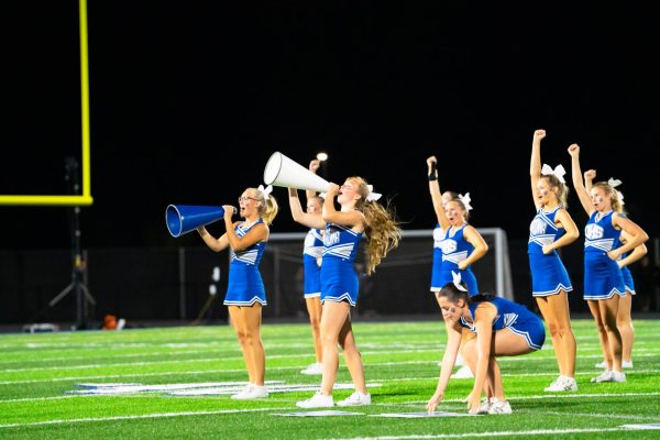 Senior Captian Mia Armstrong and Senior Ellie Vortherms cheer loud at halftime.