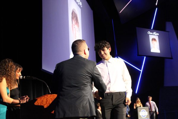 Junior Bradyn Jamaica walks the stage to shake Principal Kory Kath's hand.