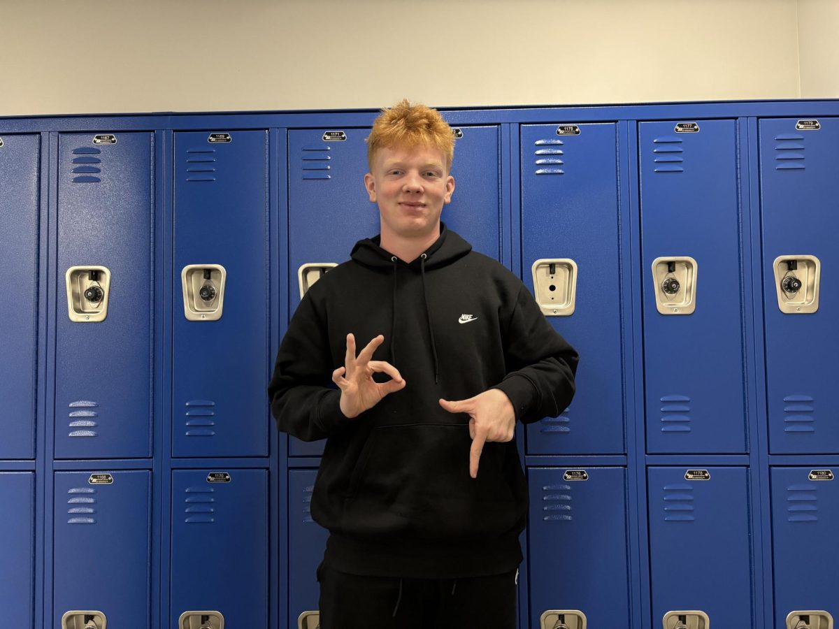 Junior Ben Sackett holding up ‘67’ on his fingers in the OHS hallway.
