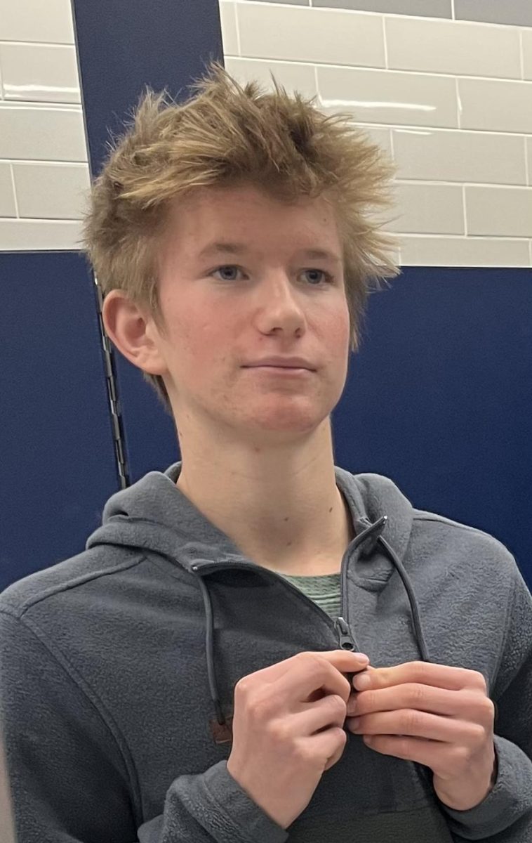 Sophomore Owen Albright adjusts his quarter-zip.