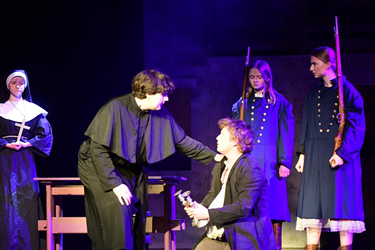Vincent Justine putting his hand on another actor while singing during the musical. 