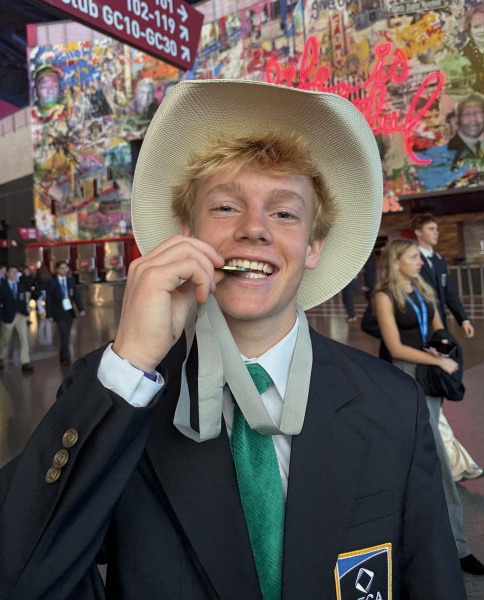 Junior, Lowell Schultz poses with his Distributive Educational Clubs of America medal and cowboy hat.